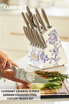 a person holding a knife on top of a cutting board with other knives in it