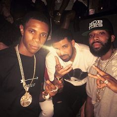 three men posing for the camera with one holding up his finger and another pointing at the camera