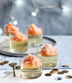 three glasses filled with food sitting on top of a table