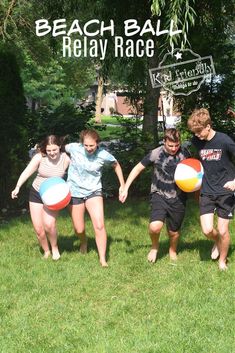 four children are playing with beach balls in the grass