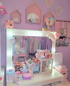 a white vanity topped with lots of toys next to a wall filled with stuffed animals