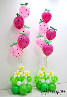 two vases filled with watermelon balloons and flowers