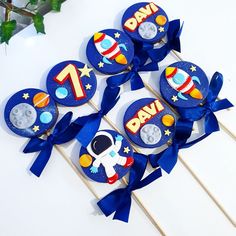 space themed cupcake toppers with blue ribbon and stars on them are arranged in the shape of an astronaut's rocket ship