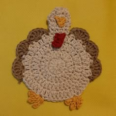 a crocheted turkey sitting on top of a yellow surface