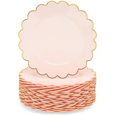 a stack of pink and gold plates with scalloped rims on top of each other