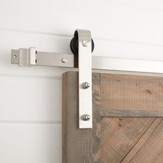 a close up of a sliding door handle on a wooden door with white paint and wood planks