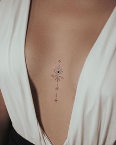 a woman's chest with an all seeing eye tattoo on it