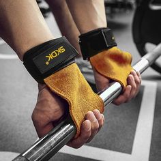 two hands with wrist pads holding barbells