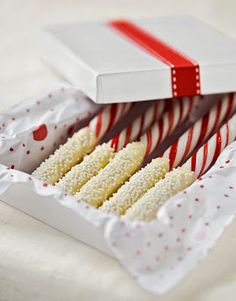 a box filled with lots of candy canes on top of a white tablecloth