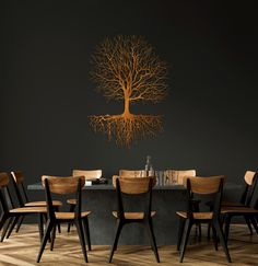 a dining room table with chairs and a tree on the wall