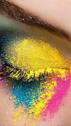 a woman's eye with bright makeup and colorful powder on the iris eyeshadow