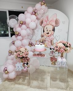 a table topped with balloons and flowers next to a cake