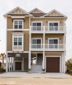 a two story house with multiple balconies on the second floor