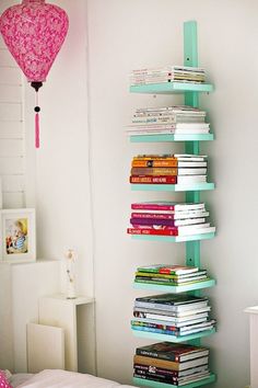 a room with a bed, bookshelf and pink balloons in the air hanging from the ceiling