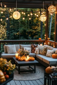 an outdoor patio decorated for fall with pumpkins and lanterns