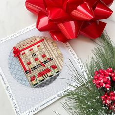 a red bow is on top of a card next to some flowers and a plant