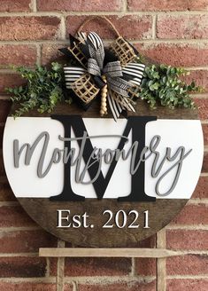 a wooden sign with the word montgomery on it and a bow hanging from it's side