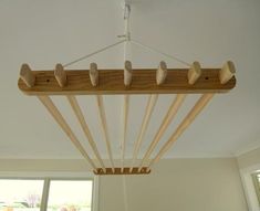 several wooden pegs hang from the ceiling above a bed