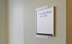 a sign mounted to the side of a wall next to a door in an office