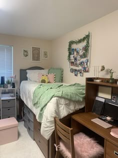 a bedroom with a bed, desk and computer on the dresser in front of it