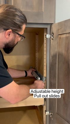 a man in black shirt working on cabinets