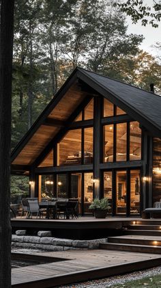 a large wooden cabin in the woods with stairs leading up to it's entrance