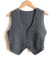 a gray sweater vest hanging on a wooden hanger