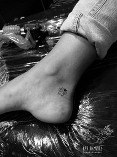 a dog paw tattoo on the ankle