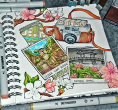 an open sketchbook with pictures and flowers on the pages, along with pens and markers