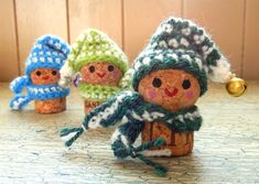 three small crocheted snowmen sitting next to each other on top of a table