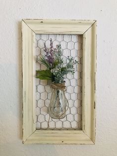 a vase with flowers in it hanging on a wall