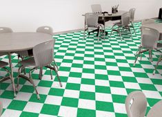 a room that has green and white checkered flooring on the floor, with tables and chairs in it