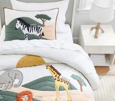 a bed with a zebra, giraffe and elephant on it