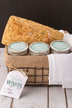 a loaf of bread sitting on top of a wooden table next to two jars of soap