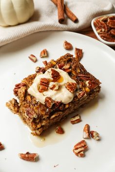 a white plate topped with granola bars covered in frosting and pecanse