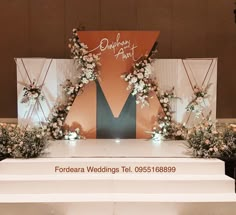 the stage is set up with flowers and greenery on it for a wedding ceremony