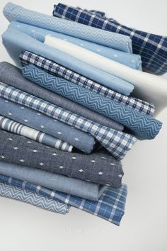 a stack of folded blue and white cloths on top of each other in different patterns