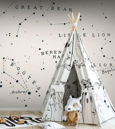 a child's teepee tent in front of a wall with stars