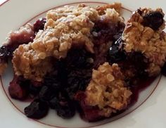 a white plate topped with blueberry crumbles covered in oatmeal