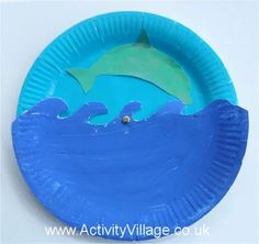 a blue paper plate with a dolphin on it and some water in the middle that has been cut out