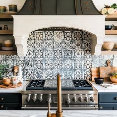 a stove top oven sitting inside of a kitchen next to a counter with pots and pans on it