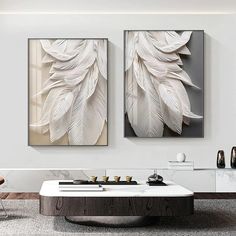 two paintings are hanging on the wall above a coffee table in a modern living room