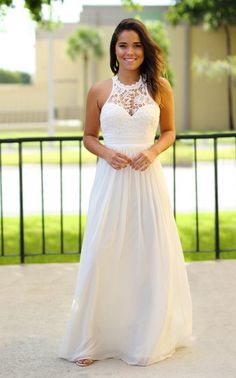 a woman in a white dress posing for the camera