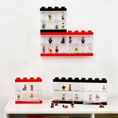 legos are arranged on shelves in front of a white wall