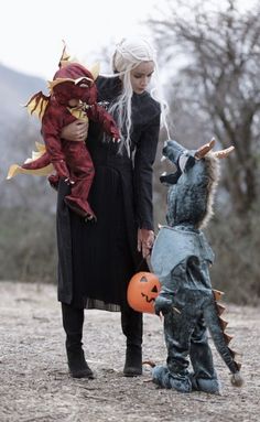 a woman holding a child in her arms and two other children dressed up as witches