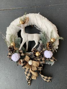 a wreath with a deer and pine cones on it