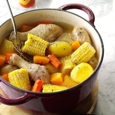 a pot filled with chicken, corn and potatoes