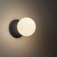 a light that is on the wall next to a moon and a black object in it