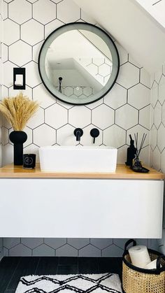 a bathroom with a sink, mirror and rug