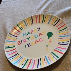 a birthday plate with the words happy birthday izac written in multicolored letters